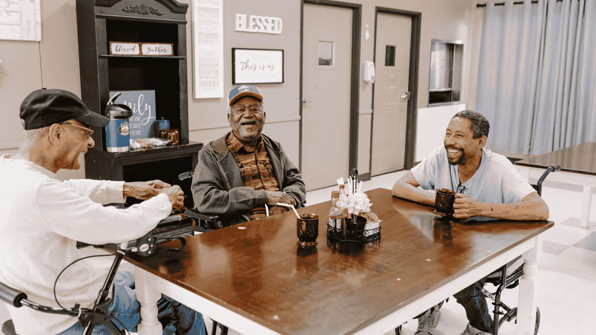 group of men sitting at dining table at lake village rehab center
